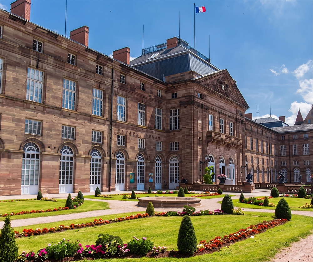Façade majestueuse du château des Rohan à Saverne entourée de jardins fleuris