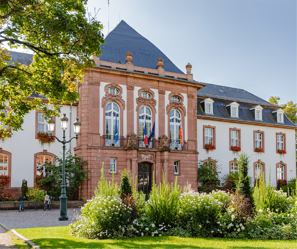 Façade baroque fleurie de l'hôtel de ville de Haguenau entourée de verdure