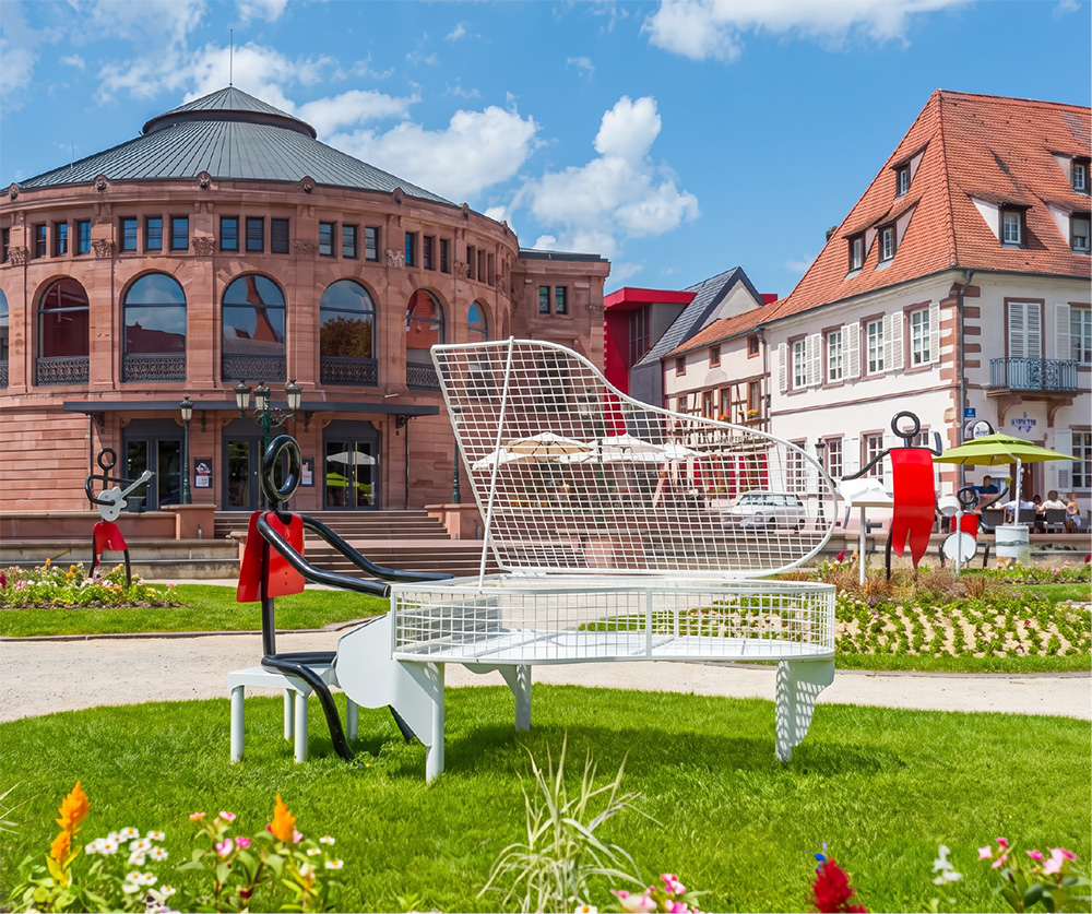 Place de Haguenau avec sculpture piano, théâtre en grès rose et bâtiments alsaciens colorés