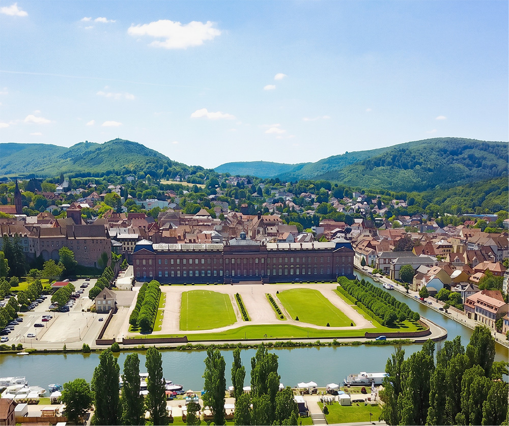 Vue aérienne de Saverne avec le château des Rohan, le canal et les collines vosgiennes